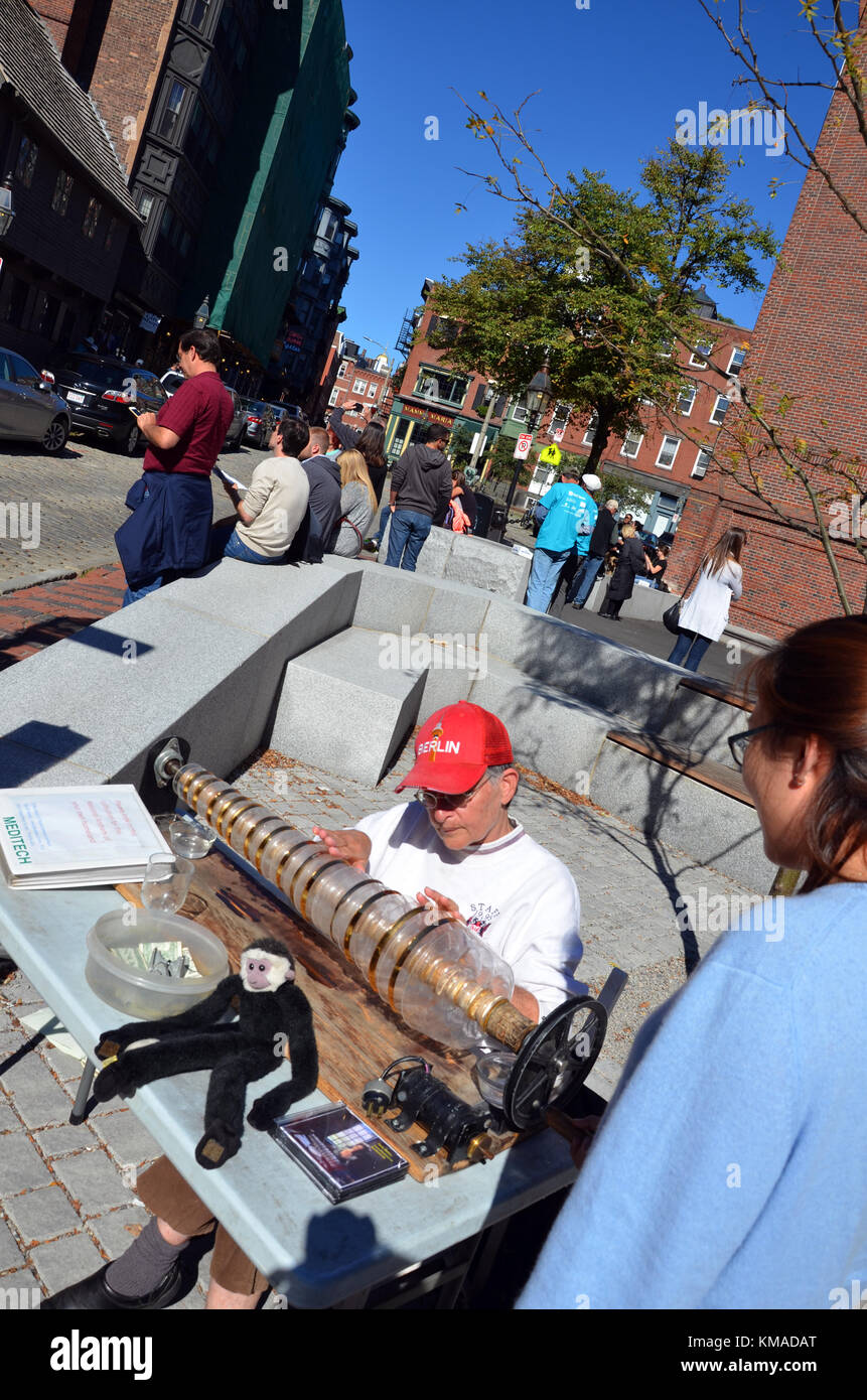 Donna con red cappello da baseball giocando un bicchiere armonica in Rachel Revere piazza in massa di Boston, Stati Uniti d'America Foto Stock