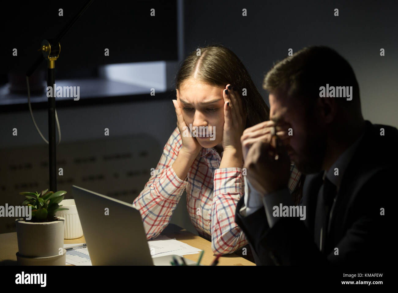 Depresso uomo d'affari infelice e donna d'affari che ha un turno di notte in ufficio e si preoccupa di problemi di lavoro. Lavoro eccessivo, scadenza, concetto di lavoro in bancarotta Foto Stock