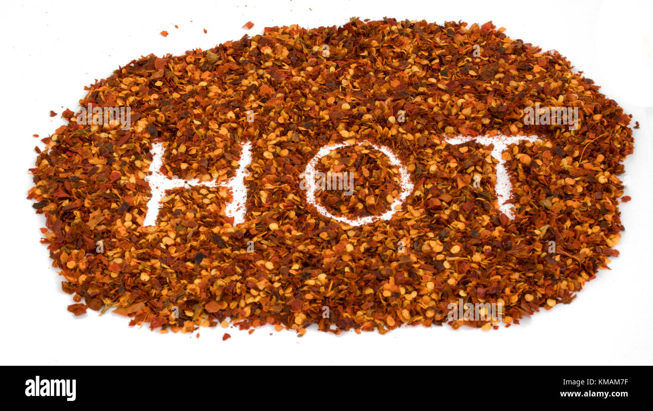 Parola hot scrivere nel peperoncino essiccato pezzi di peperone rosso schiaccia isolato - concetto a caldo Foto Stock