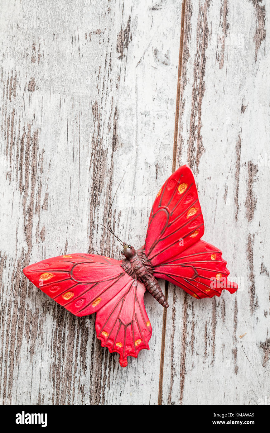 Decorativo farfalla rosso su bianco sullo sfondo di legno Foto stock - Alamy