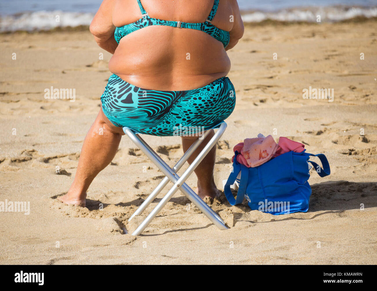 Vista posteriore della donna anziana in Bikini sulla spiaggia in Spagna Foto Stock