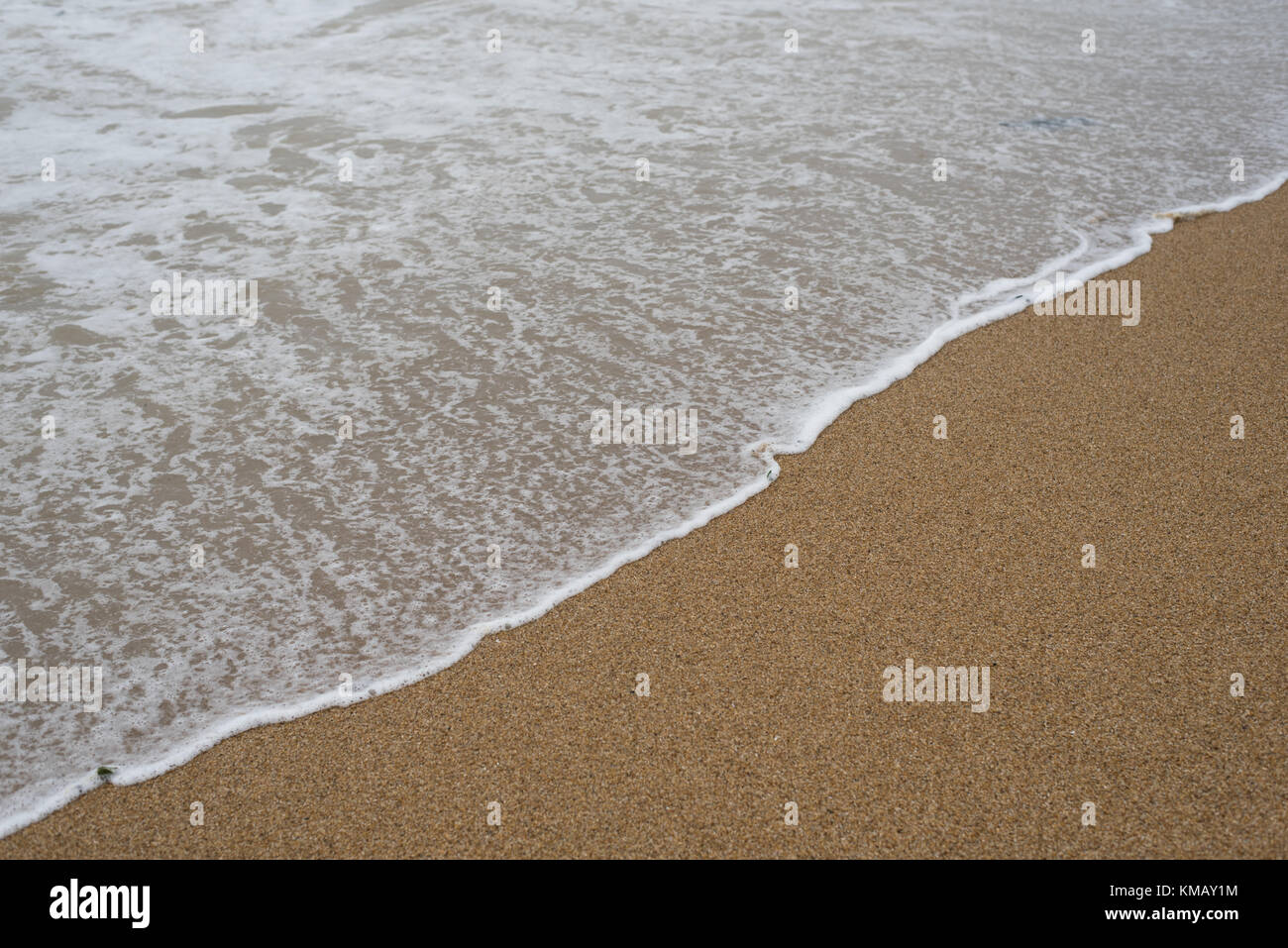 Onda morbida sulla spiaggia sabbiosa. sfondo Foto Stock