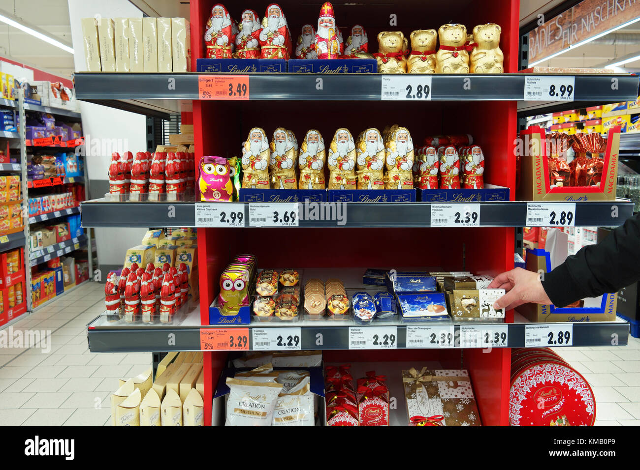 Shopper selezionando Natale regali di cioccolato in un supermercato. Foto Stock
