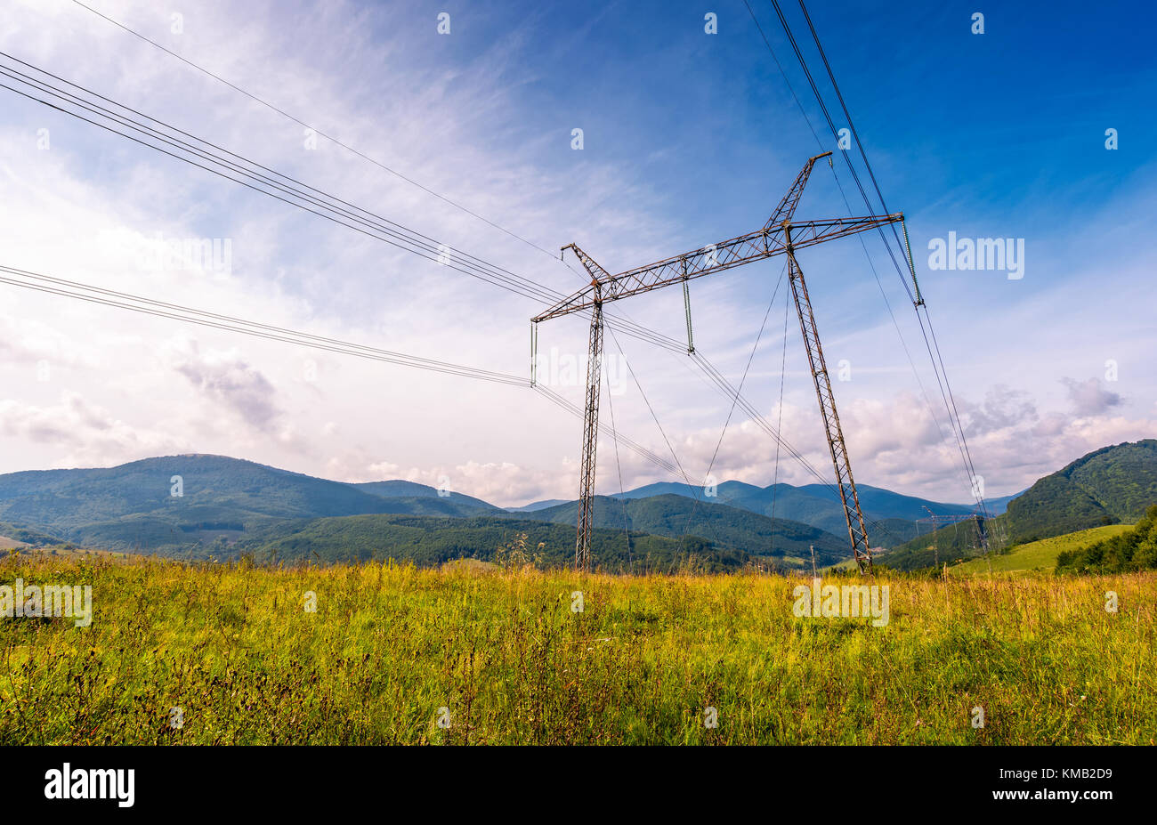 Le linee elettriche in alta tensione nella torre dei Carpazi. bel verde industria energetica concetto. bellissimo paesaggio in autunno con cielo blu e alcuni clo Foto Stock