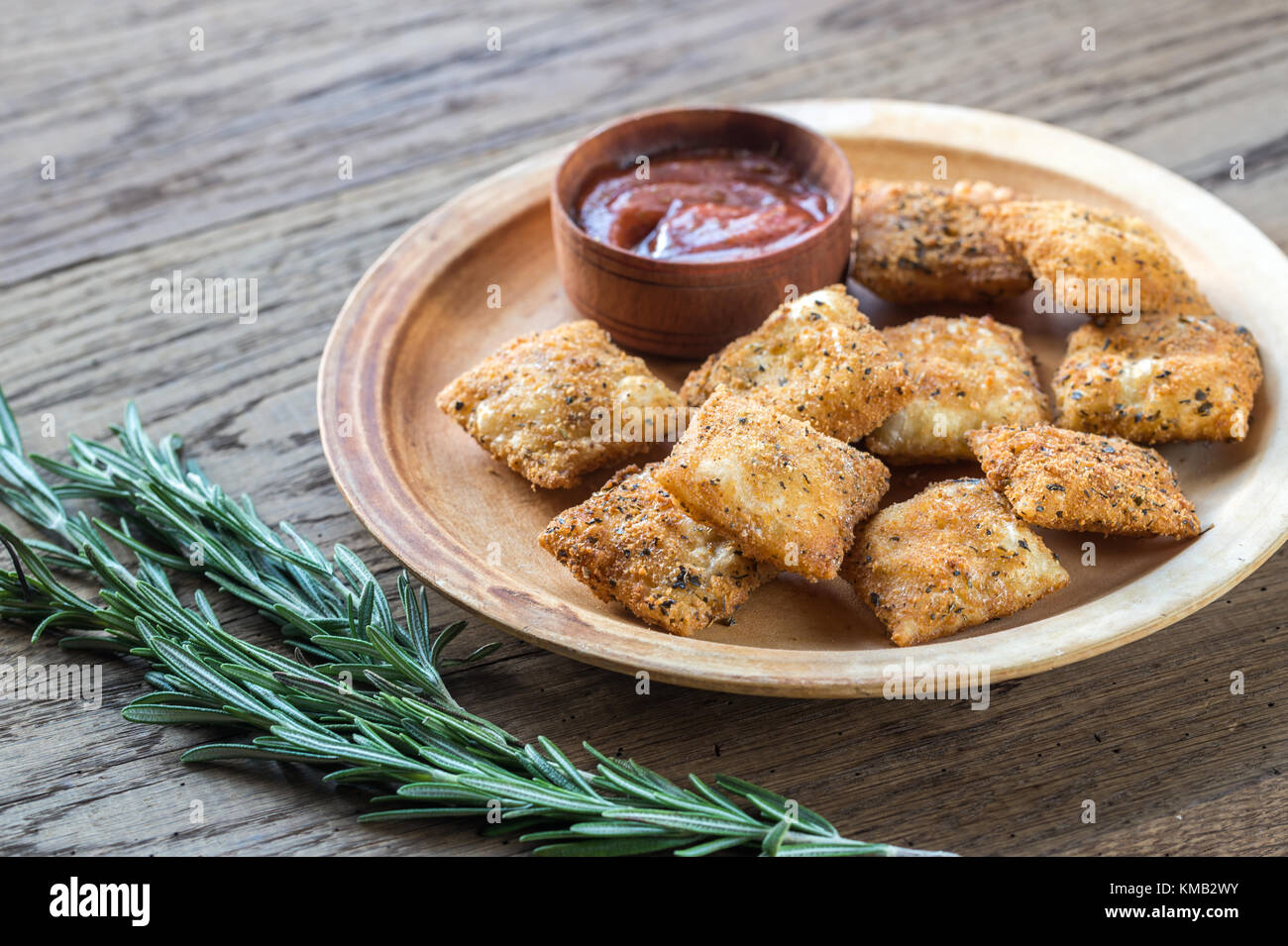 Piastra con ravioli fritti sulla tavola di legno Foto Stock