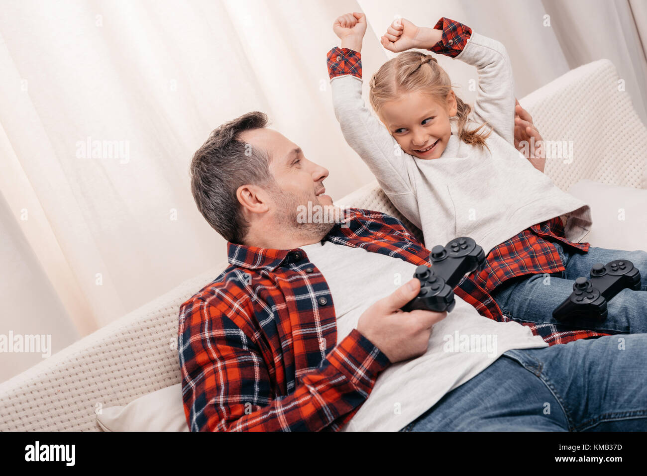 Padre e figlia giocare con joystick Foto Stock