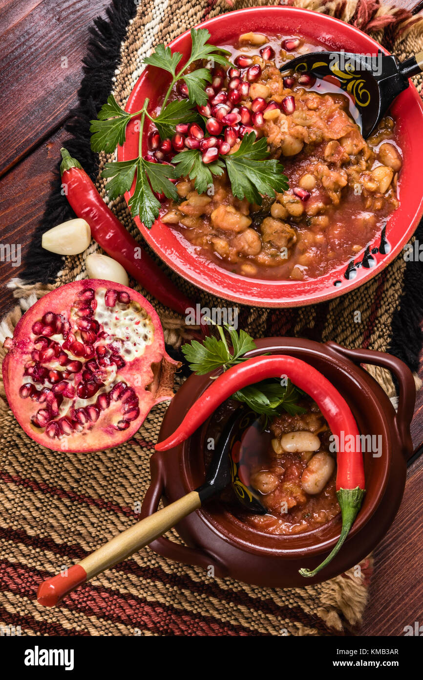 Top View Studio di cibo vegetariano con fagioli piatto piccante con pepe e melograno Foto Stock