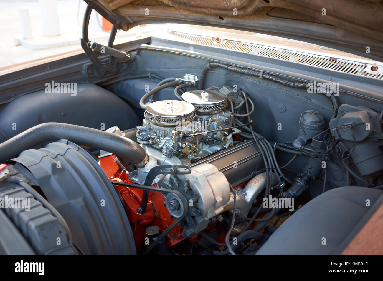 Close-up di il motore di una vecchia auto americana con cappa aperta in un'automobile repair shop Foto Stock