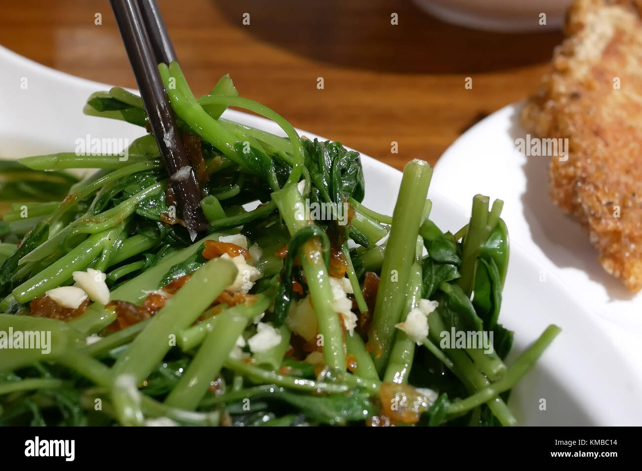 Il movimento di persone mangiare verdura all'interno del ristorante cinese Foto Stock