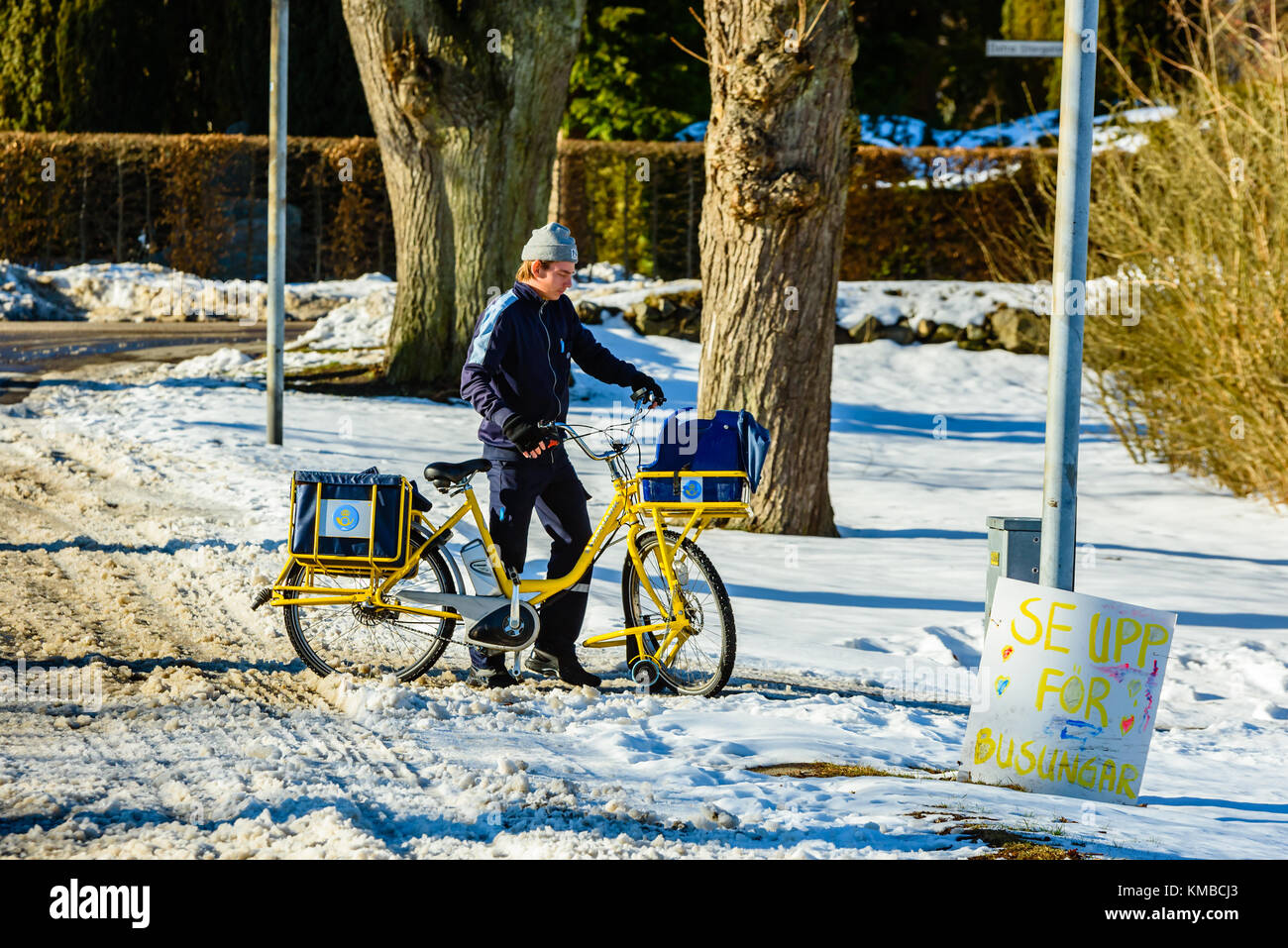 Solvesborg, Svezia - 14 febbraio 2017: documentario di portalettere avendo difficoltà in bicicletta nel difficile granite. egli è costretto a portare la bici attraverso di esso. un Foto Stock