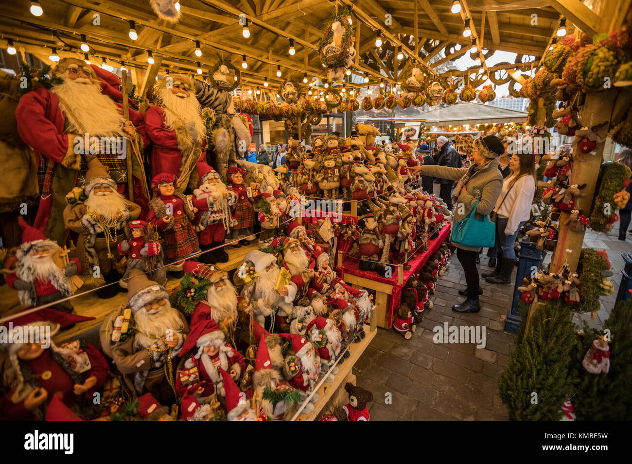 People shopping presso le bancarelle del mercato con merci di natale a Manchester Mercatini di Natale intorno alla città, Manchester, Inghilterra, Regno Unito Foto Stock