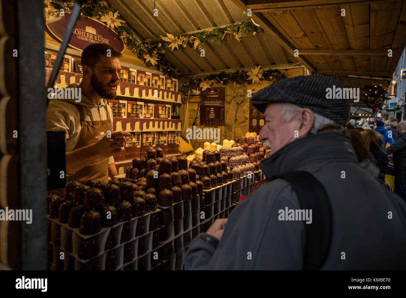 Stallo del mercato lavoratore che serve cibo a Manchester Mercatini di Natale intorno alla città, Manchester, Inghilterra, Regno Unito Foto Stock