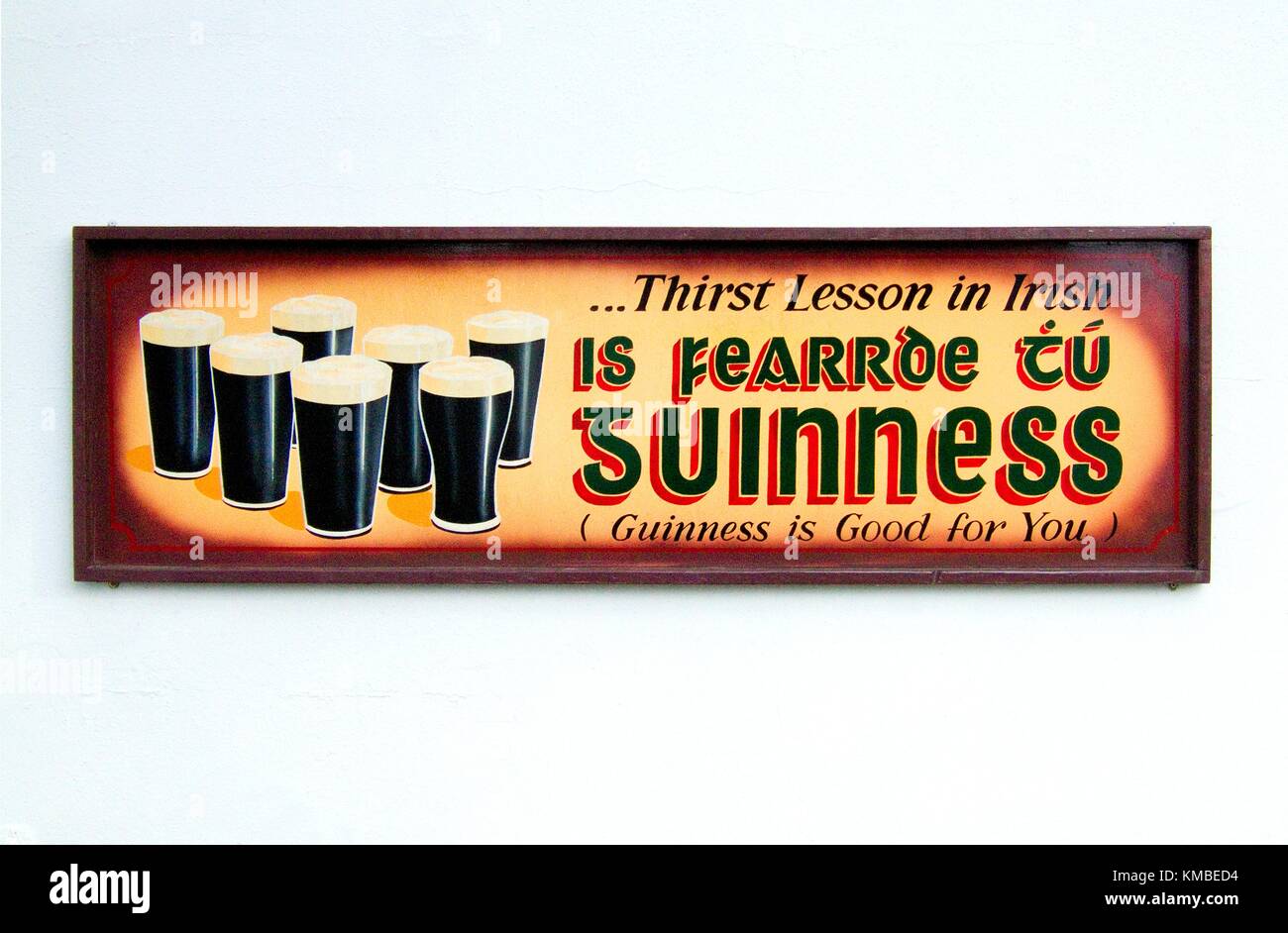 Vecchio tradizionale pinta di Guinness pubblicità segno in lingua irlandese su pub bar parete ovunque in Irlanda. Foto Stock