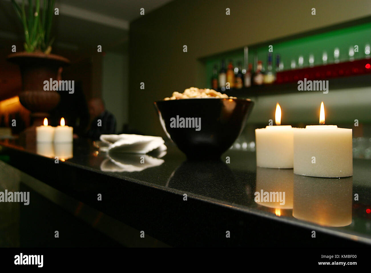 Un bar del ristorante è preparato per l'arrivo dei commensali, allestito e pronto con candele accese, tovaglioli e stoviglie Foto Stock