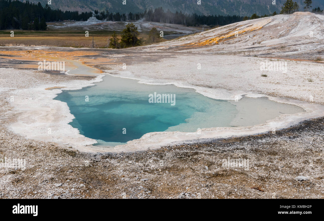 Aqua primavera calda a yellowstone oltre il paesaggio di dolci colline Foto Stock