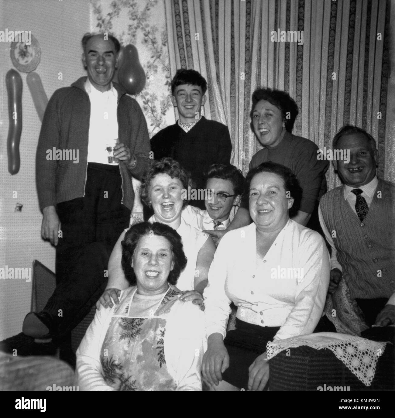 Degli anni Cinquanta, storici festa di famiglia, foto mostra le diverse generazioni di una famiglia di ridere insieme a un party, Inghilterra, Regno Unito. Foto Stock