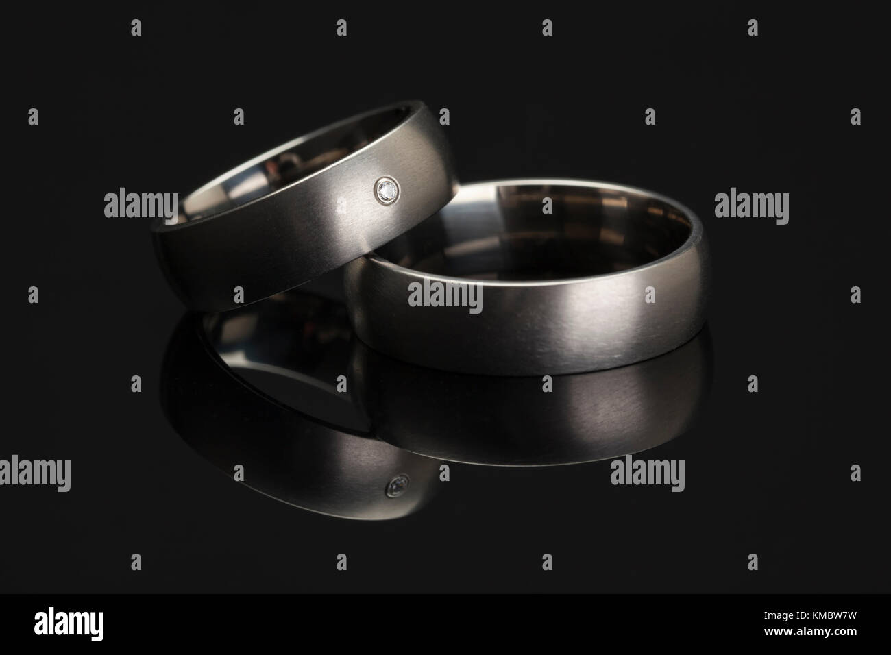 Platino anelli di nozze riflettente sulla superficie nera Foto Stock