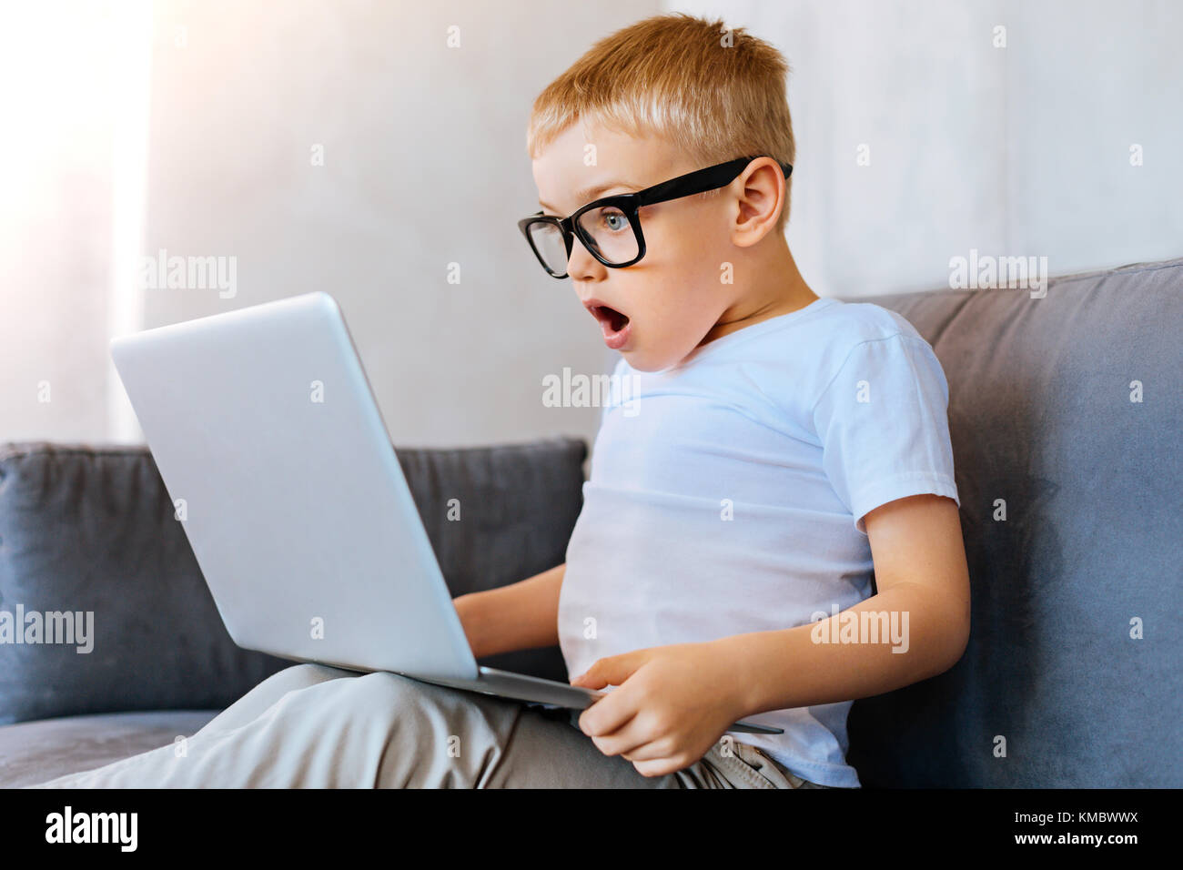 Bel ragazzo emotivo guardando lo schermo del laptop Foto Stock