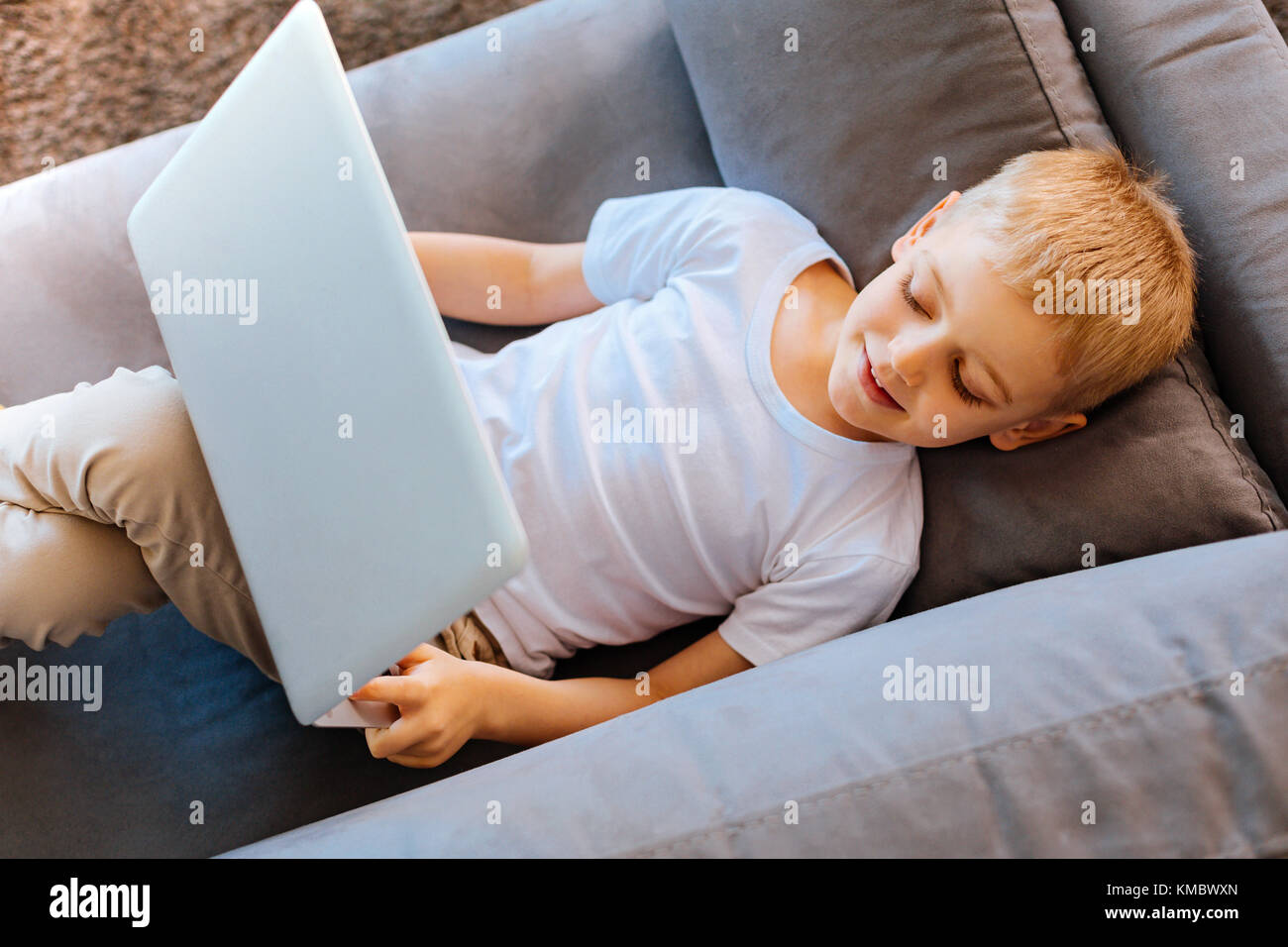 Piacevole lieti boy in appoggio sul divano Foto Stock