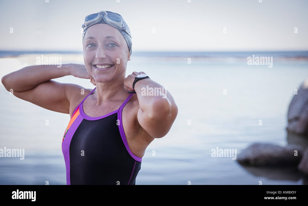 Ritratto sorridente femmina in acqua aperta nuotatore regolare costume da bagno in oceano Foto Stock