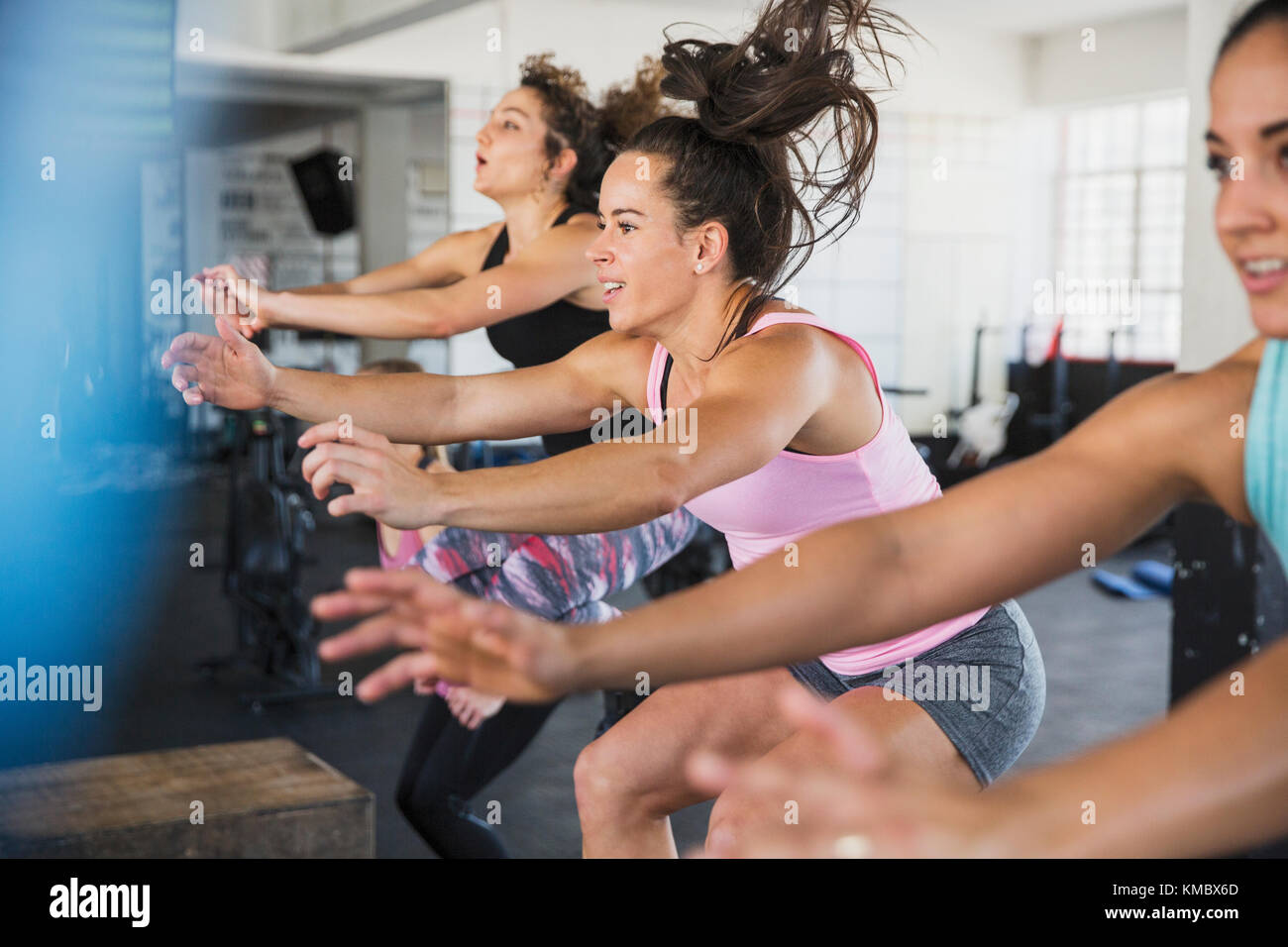 Giovani donne energiche che cavalcano biciclette ellittiche in classe di esercizio Foto Stock