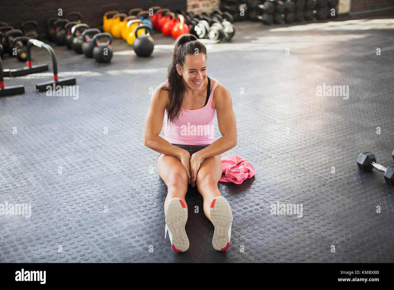 Giovane donna muscolare che allunga le gambe in palestra Foto Stock