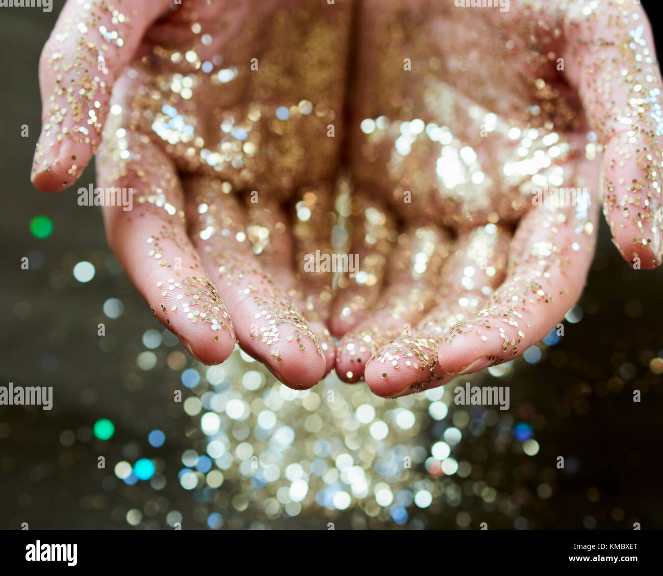 Le mani oro cupping glitter Foto Stock