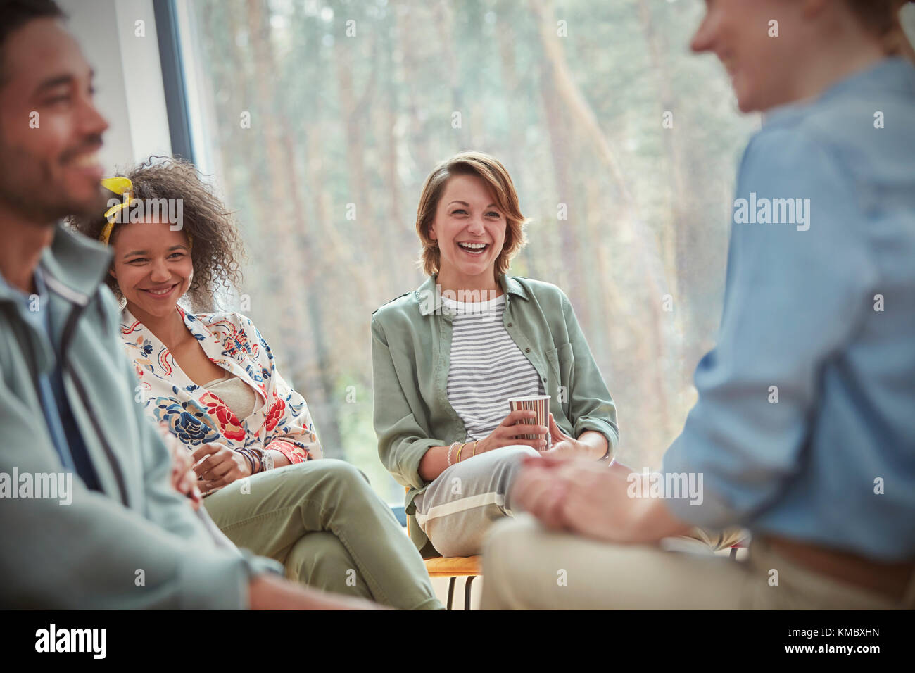 Persone sorridenti e ridenti in una sessione di terapia di gruppo Foto Stock