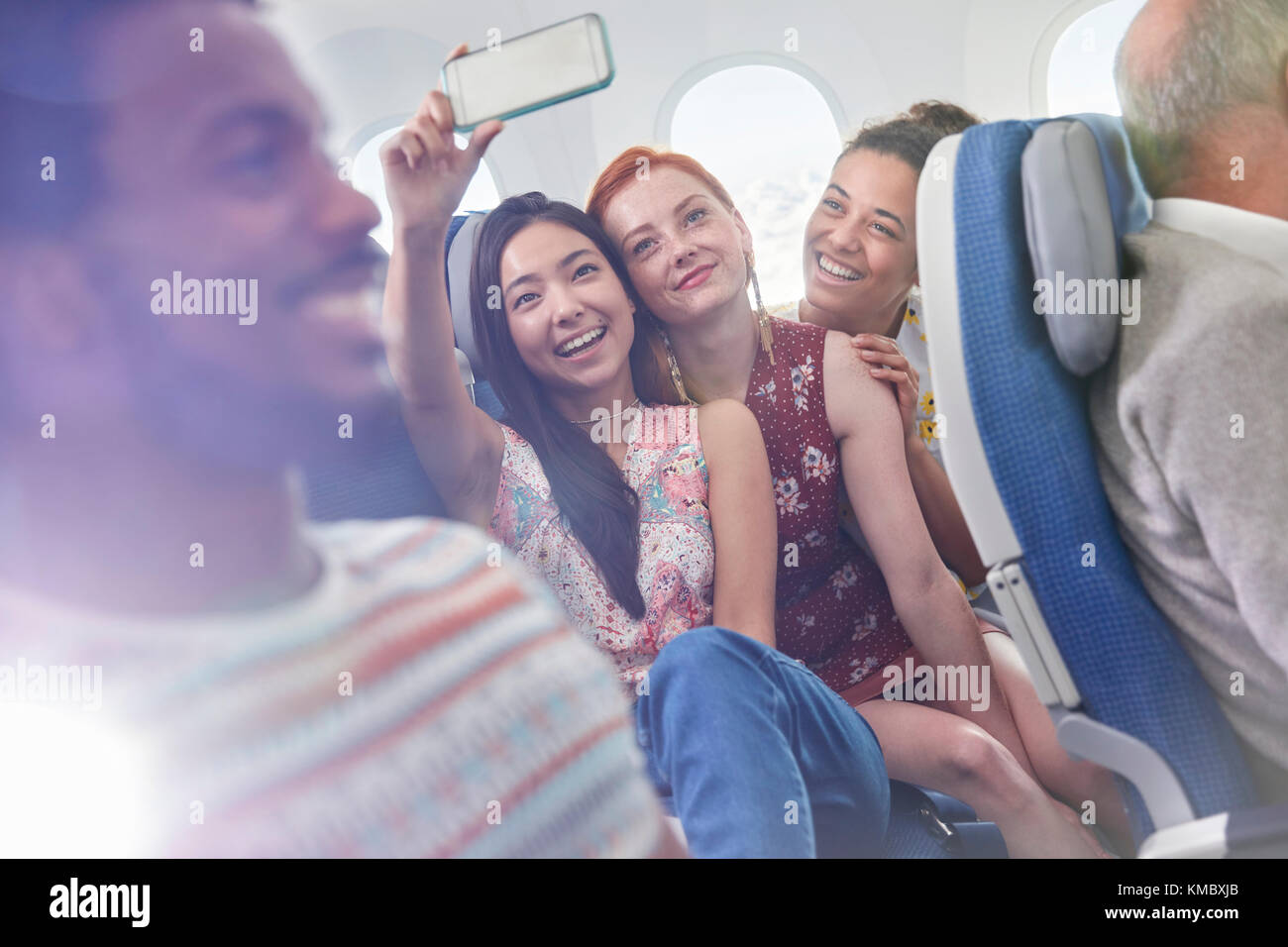 Giovani donne amici con fotocamera telefono che prende selfie in aereo Foto Stock