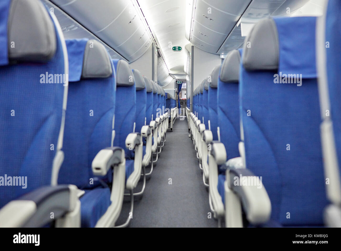 Sedili blu vuoti in fila in aereo Foto Stock