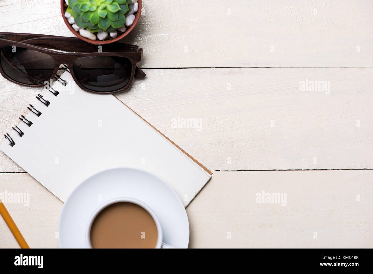 Immagine della pagina vuota della piccola nota con una matita, una tazza di caffè su sfondo di legno Foto Stock