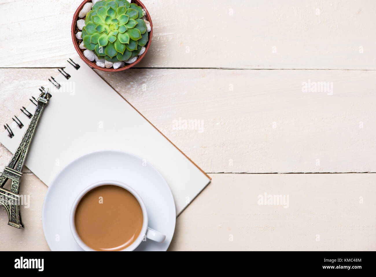 Immagine della pagina vuota della piccola nota con una matita, una tazza di caffè su sfondo di legno Foto Stock