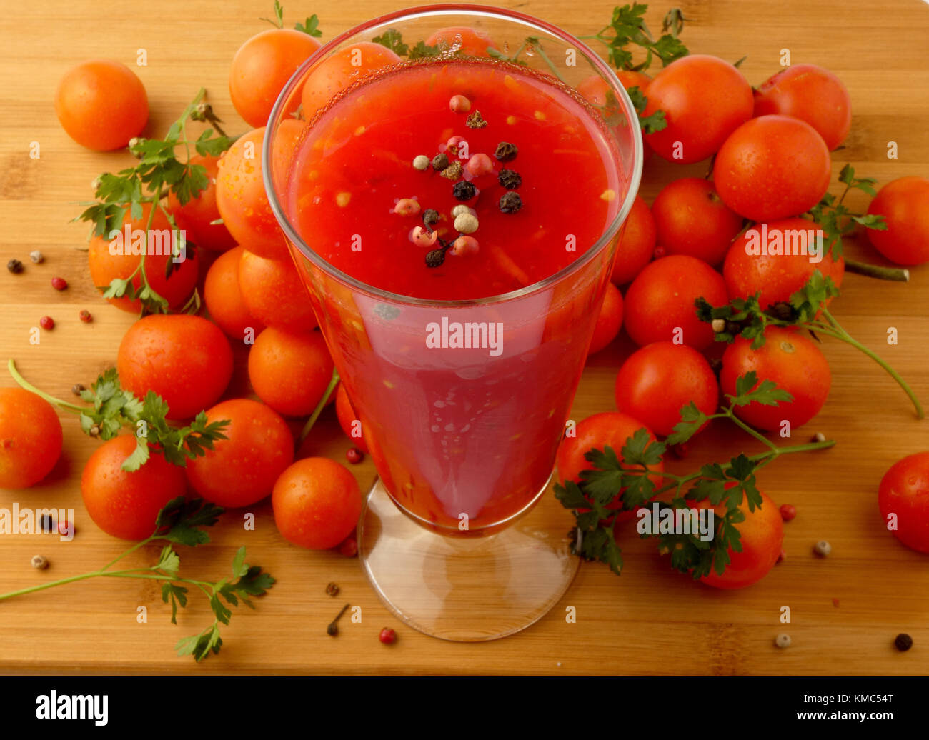 Tamoto succo con pepe e pomodori ciliegia sulla tavola in legno isolato Foto Stock