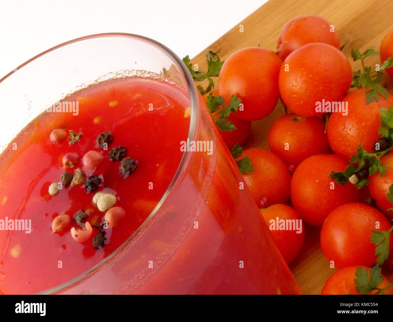 Tamoto succo con pepe e pomodori ciliegia sulla tavola in legno isolato Foto Stock