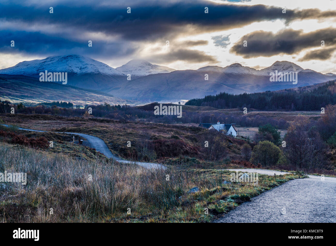 La vista a sud da circa Dalrigh, appena a sud di Tyndrum. Come il sole sorge su colline Crianlarich - Ben più, Stob Binnein e Cruach Ardrain. Foto Stock