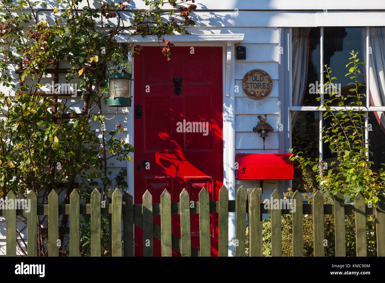 Un bel rosso porta anteriore di un cottage weatherboard house Foto Stock