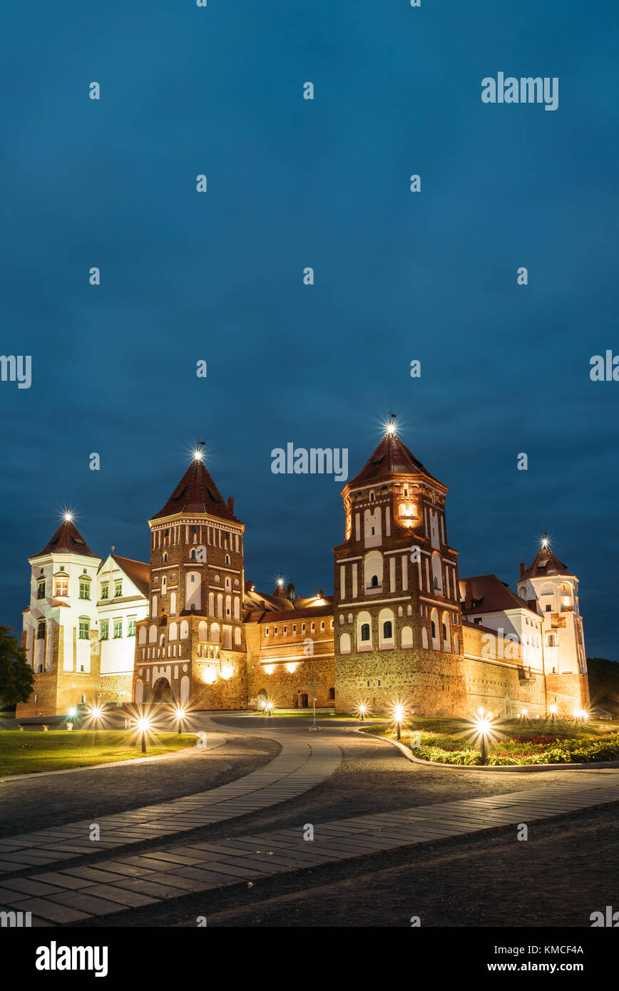 Mir, Bielorussia. complesso del Castello di Mir in serata illuminazione illuminazione. famoso punto di riferimento, antico monumento gotico del feudalesimo sotto la notte blu cielo. UNESCO Foto Stock