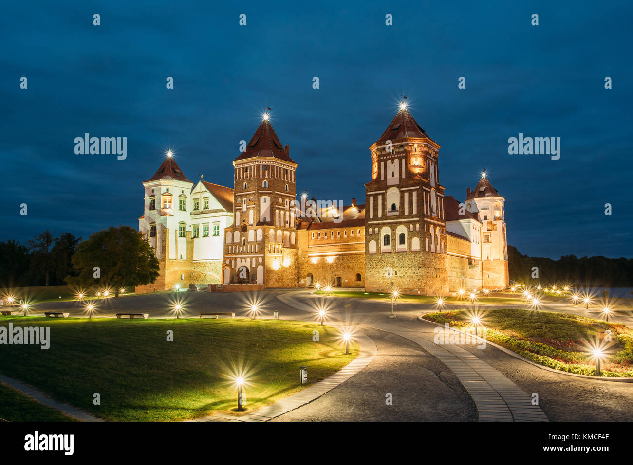 Mir, Bielorussia. complesso del Castello di Mir in serata illuminazione illuminazione. famoso punto di riferimento, antico monumento gotico del feudalesimo sotto la notte blu cielo. UNESCO Foto Stock