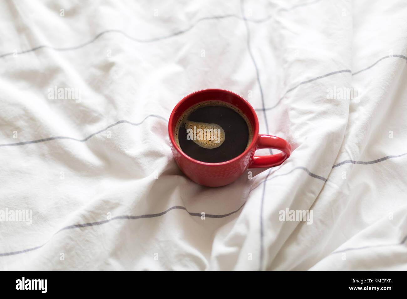 Il caffè nella tazza rossa servita a letto Foto Stock