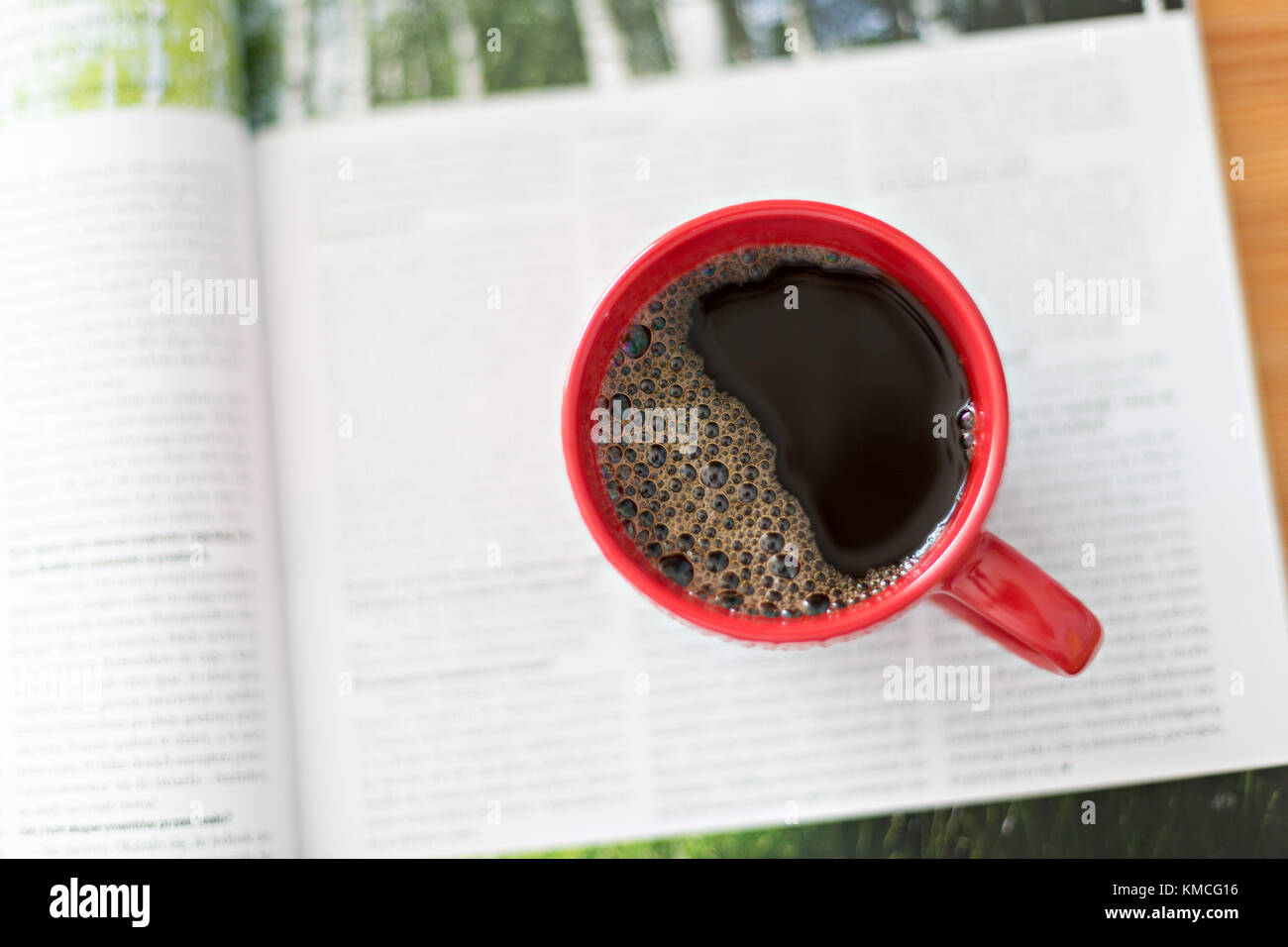 Il caffè nella tazza rossa e il giornale Foto Stock
