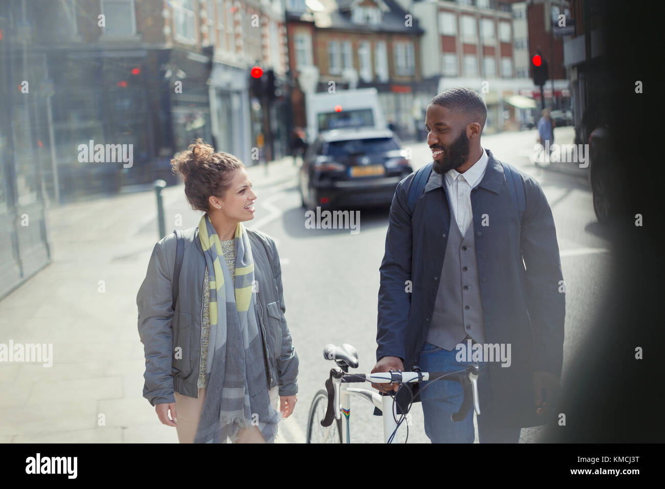 A piedi in coppia, con la bicicletta in strada urbana Foto Stock
