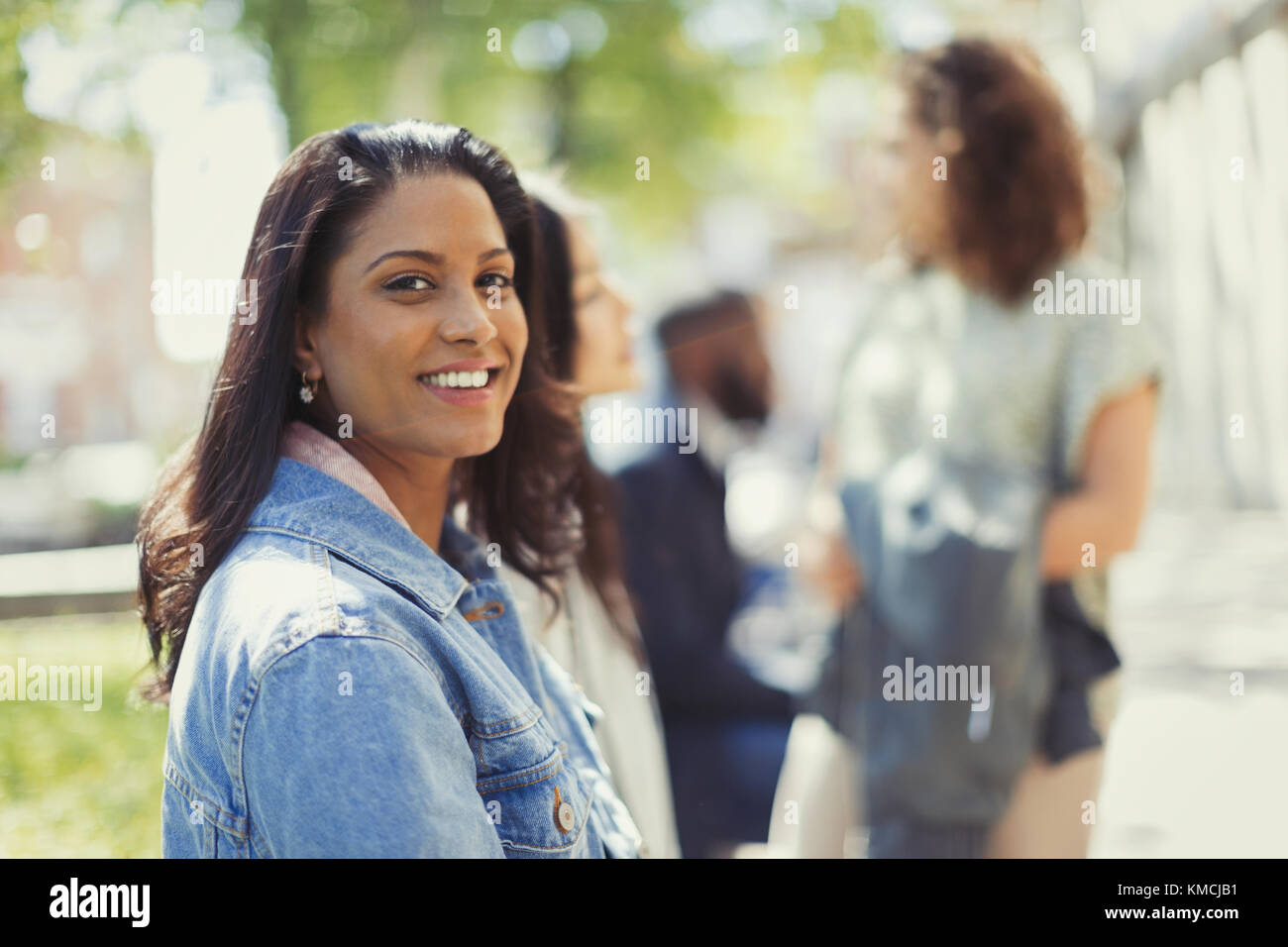 Ritratto sorridente, donna sicura in un parco soleggiato Foto Stock