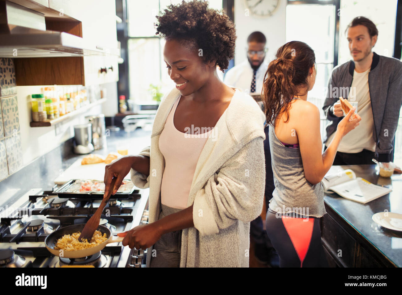 Donna che cucina uova strapazzate al piano cottura in cucina Foto Stock