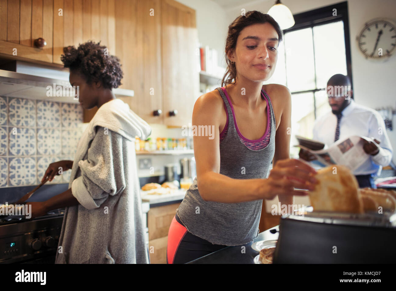 Donna che tosta il pane in cucina Foto Stock