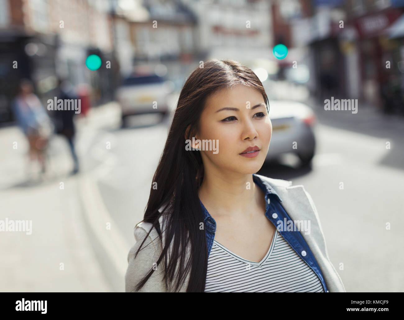 Giovane donna seria e penosa che cammina sulla strada urbana Foto Stock