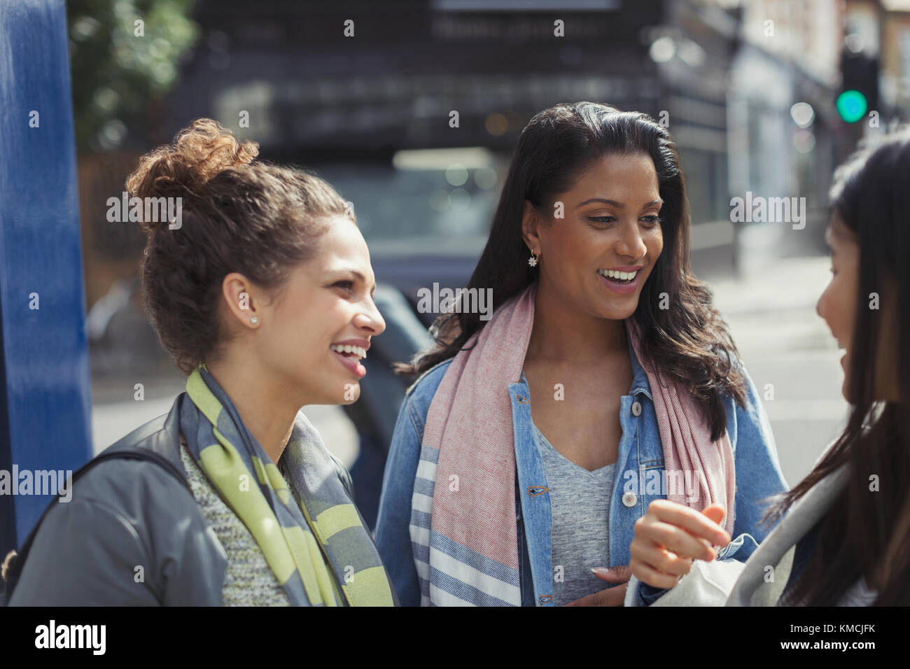 Sorridenti amici che parlano su strada urbana Foto Stock