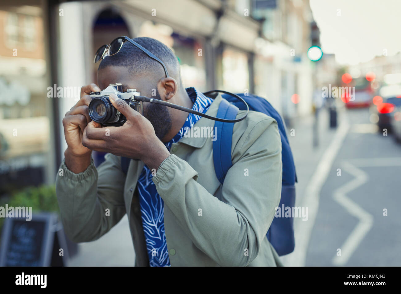 Giovane turista maschile fotografando con la macchina fotografica sulla strada Foto Stock