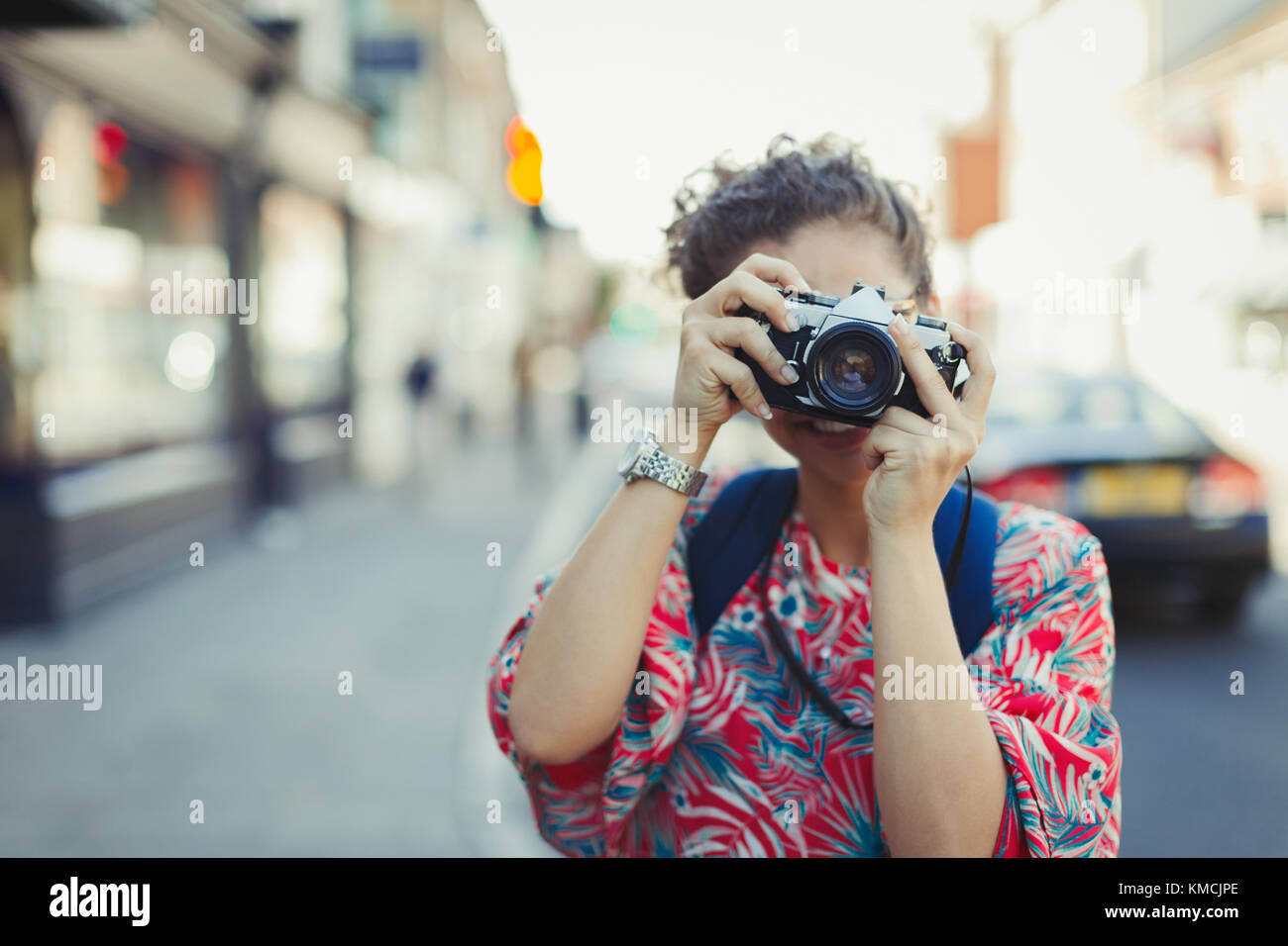 Ritratto giovane donna che fotografa con la macchina fotografica sulla strada Foto Stock