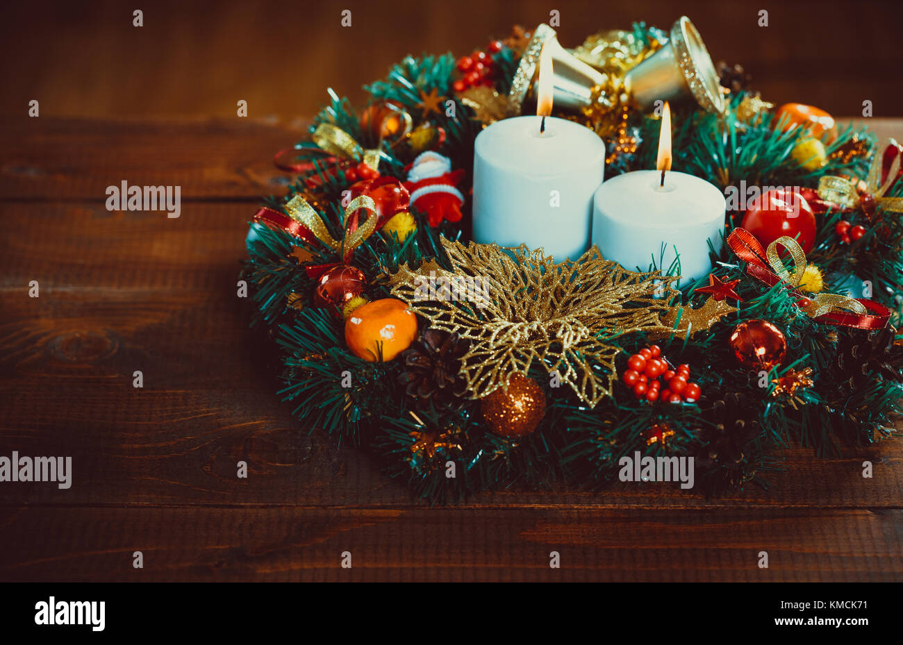 Ghirlanda di Natale con candele accese sul tavolo di legno. Bellissimo sfondo di Natale Foto Stock