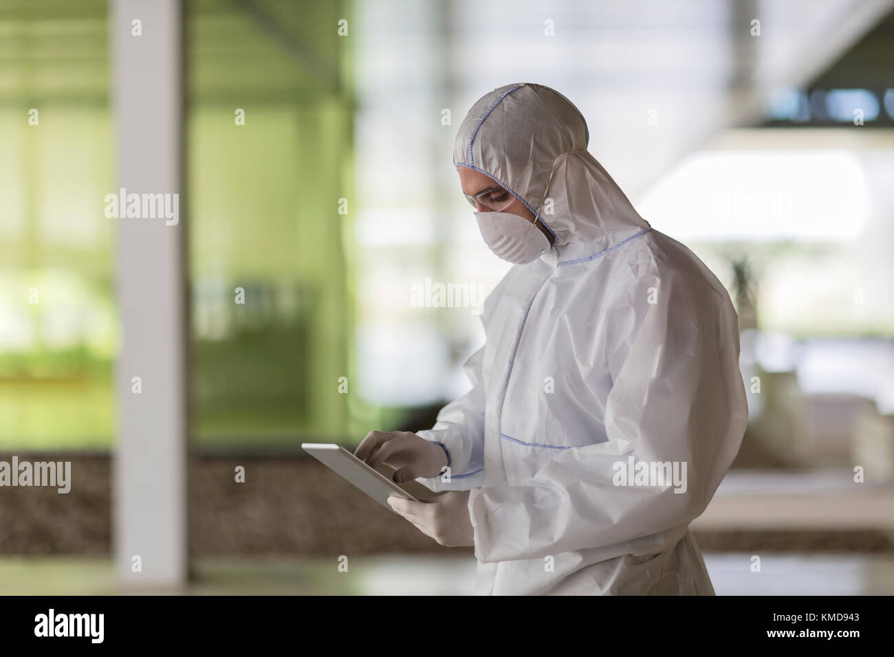 Scienziato in tuta pulita con tablet digitale Foto Stock